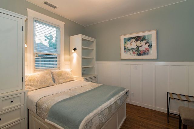 a bedroom with a bed and a painting on the wall