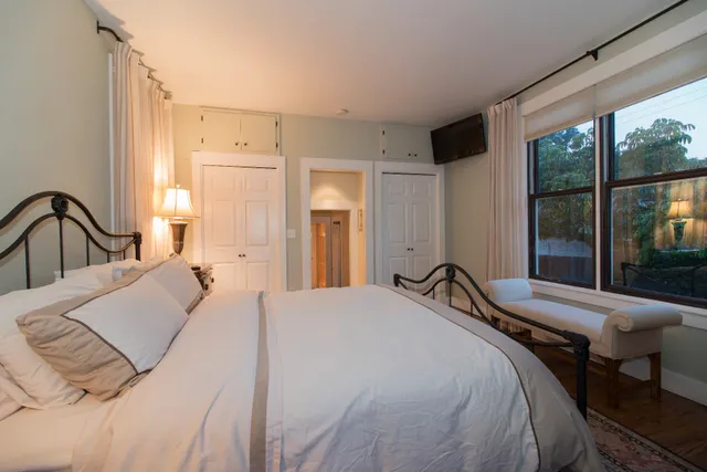 a bedroom with a bed and a large window