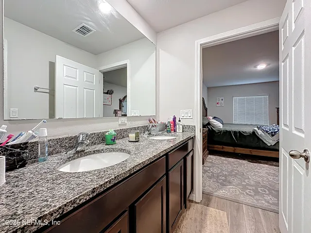 a en suite bathroom with a granite countertop sink and a mirror