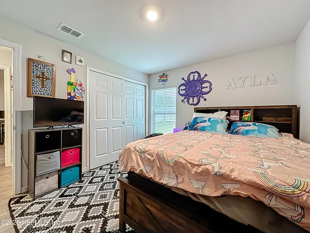 a bedroom with a bed and a flat screen tv