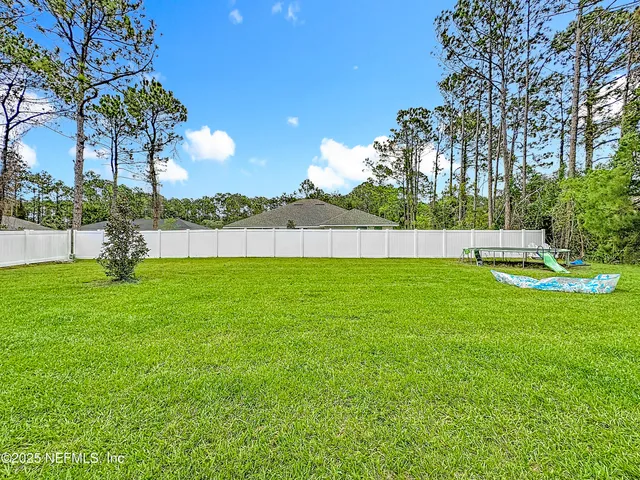 a view of yard with swimming pool and green space