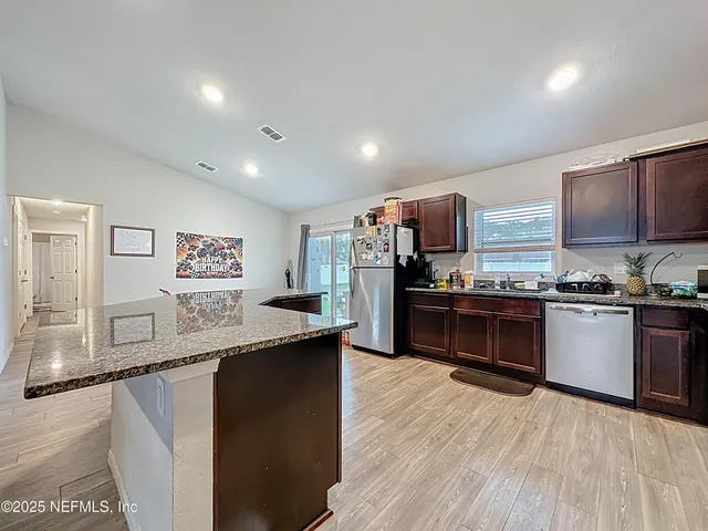 a kitchen with stainless steel appliances kitchen island granite countertop a sink counter space and stainless steel appliances