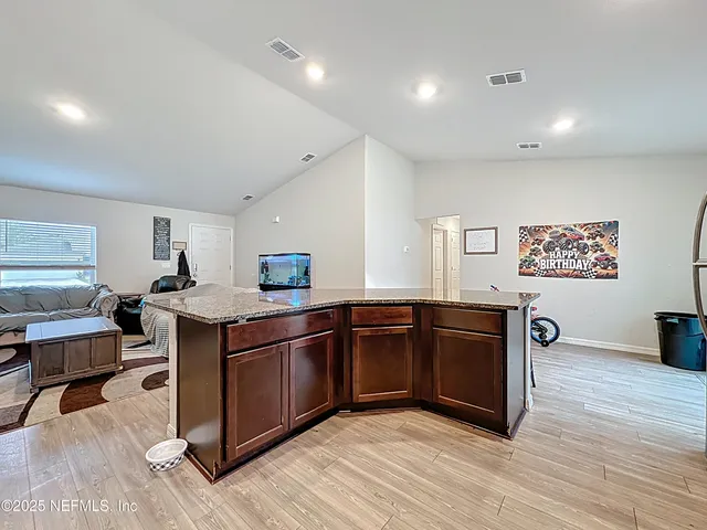 a kitchen with stainless steel appliances granite countertop a sink and a wooden floors