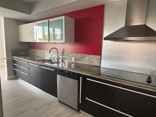 a kitchen with granite countertop a sink and a stove