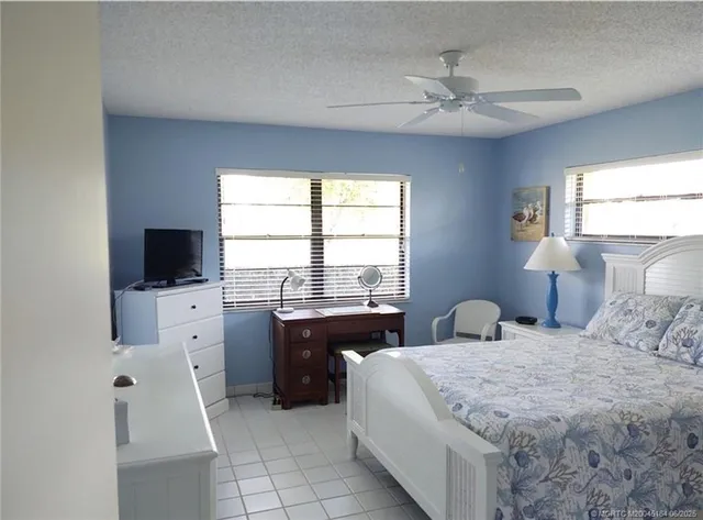 a bedroom with a bed and a flat tv screen on dresser