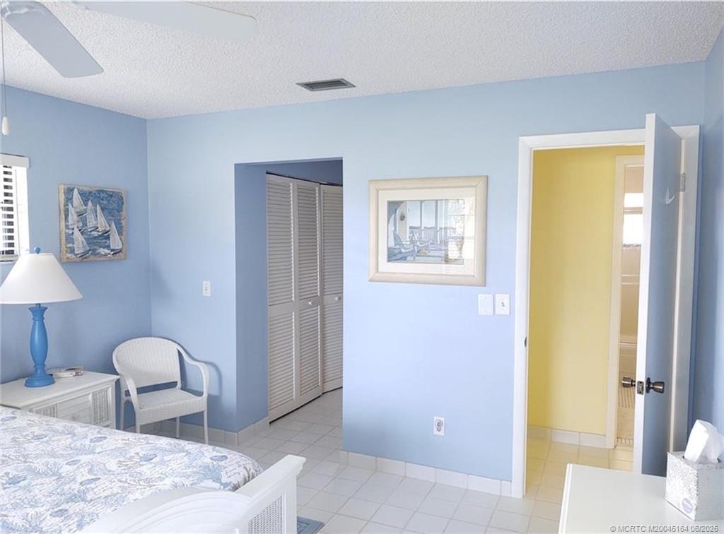 Undisclosed Address Stuart, FL 34997 - Photo 28 of 81 a bedroom with a bed and a lamp on table