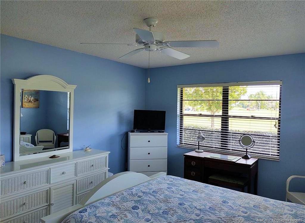 Undisclosed Address Stuart, FL 34997 - Photo 34 of 81 a bedroom with a bed and a flat tv screen on dresser