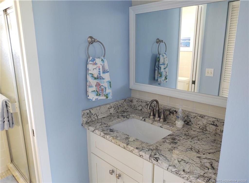 Undisclosed Address Stuart, FL 34997 - Photo 38 of 81 a bathroom with a granite countertop sink and a mirror