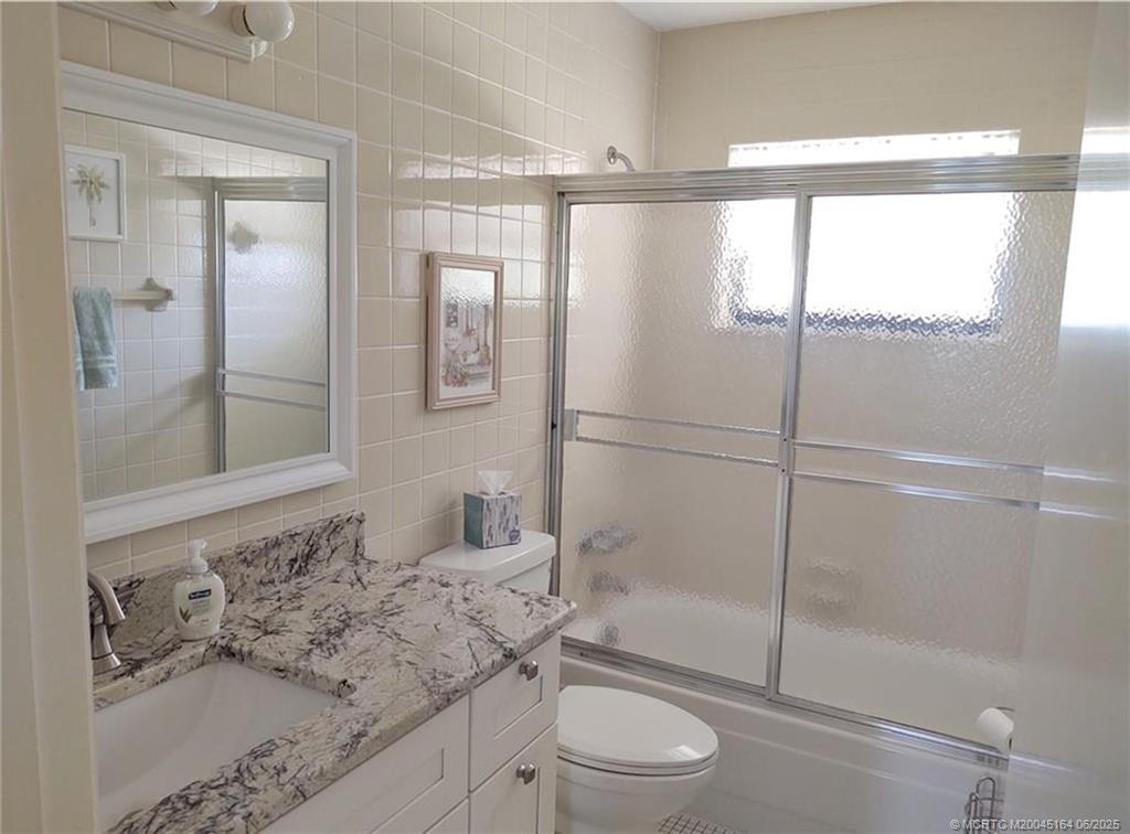 Undisclosed Address Stuart, FL 34997 - Photo 49 of 81 a bathroom with a granite countertop sink a toilet and shower