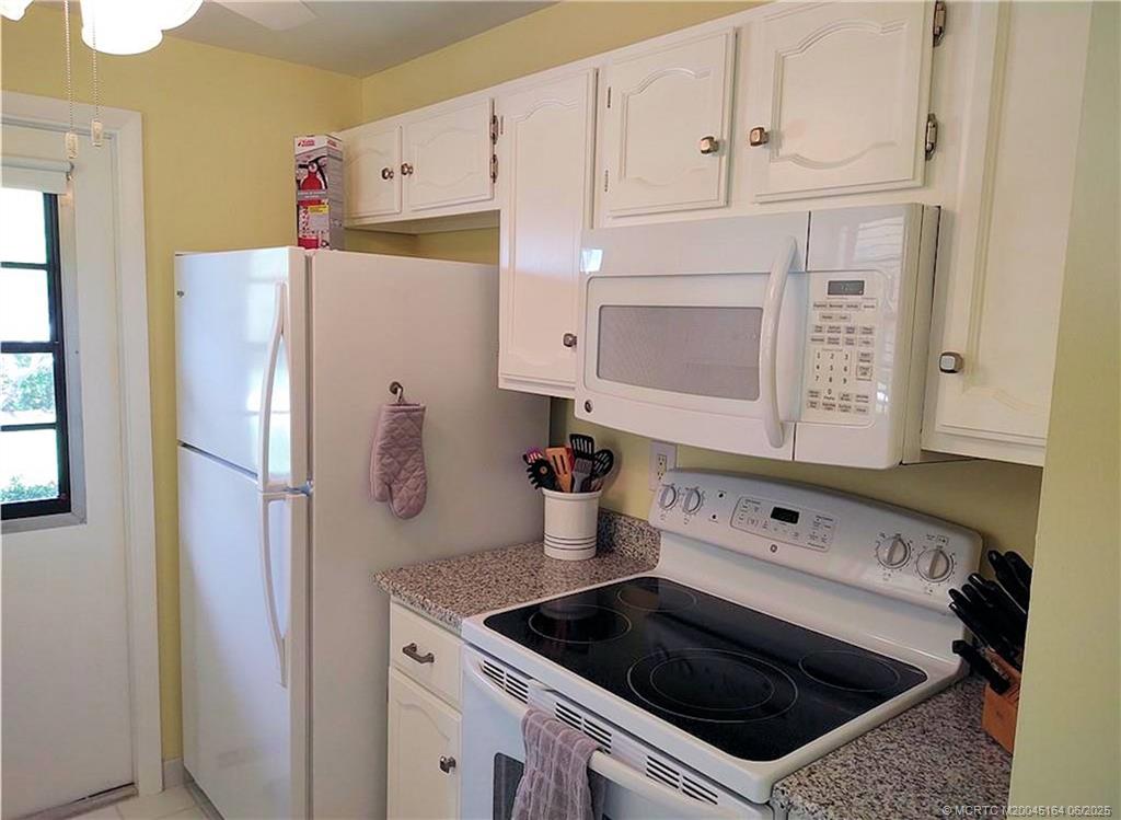 Undisclosed Address Stuart, FL 34997 - Photo 9 of 81 a kitchen with refrigerator and cabinets