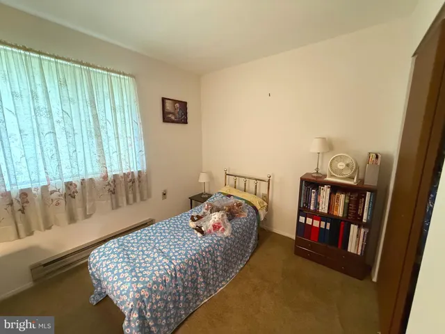 a bedroom with a bed and a book shelf
