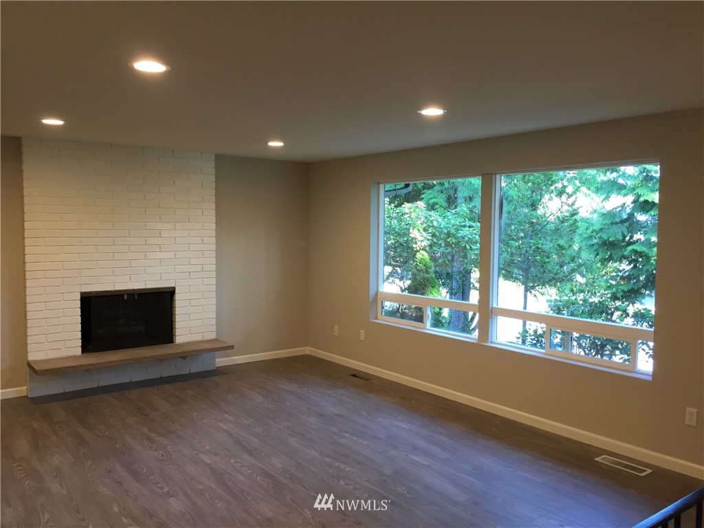 2010 Northeast 27th Street Renton, WA 98056 - Photo 3 of 16 a view of empty room with wooden floor and fireplace