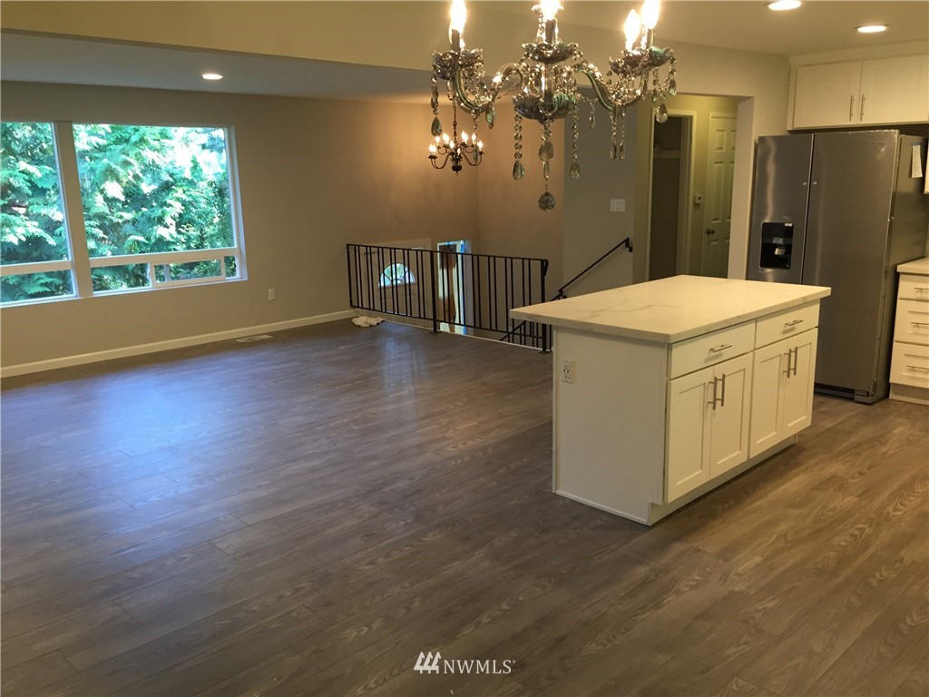 2010 Northeast 27th Street Renton, WA 98056 - Photo 4 of 16 a kitchen with stainless steel appliances a table chairs and a chandelier