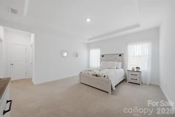 a spacious bedroom with a bed and lamp
