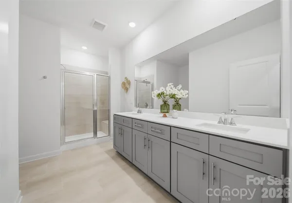 a spacious bathroom with double sink and a mirror