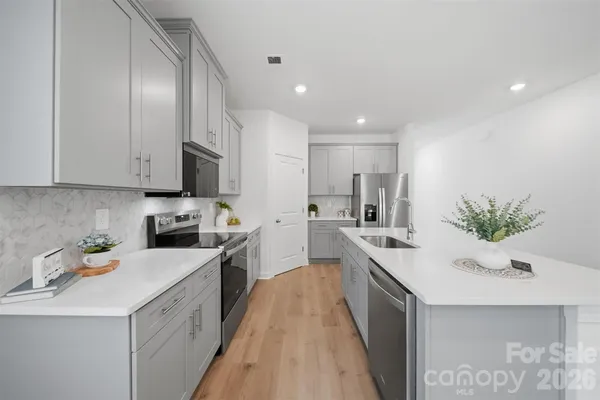 a kitchen with a sink a counter top space stainless steel appliances and cabinets