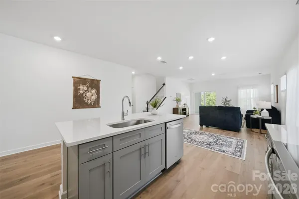 a kitchen with a sink and a wooden floor