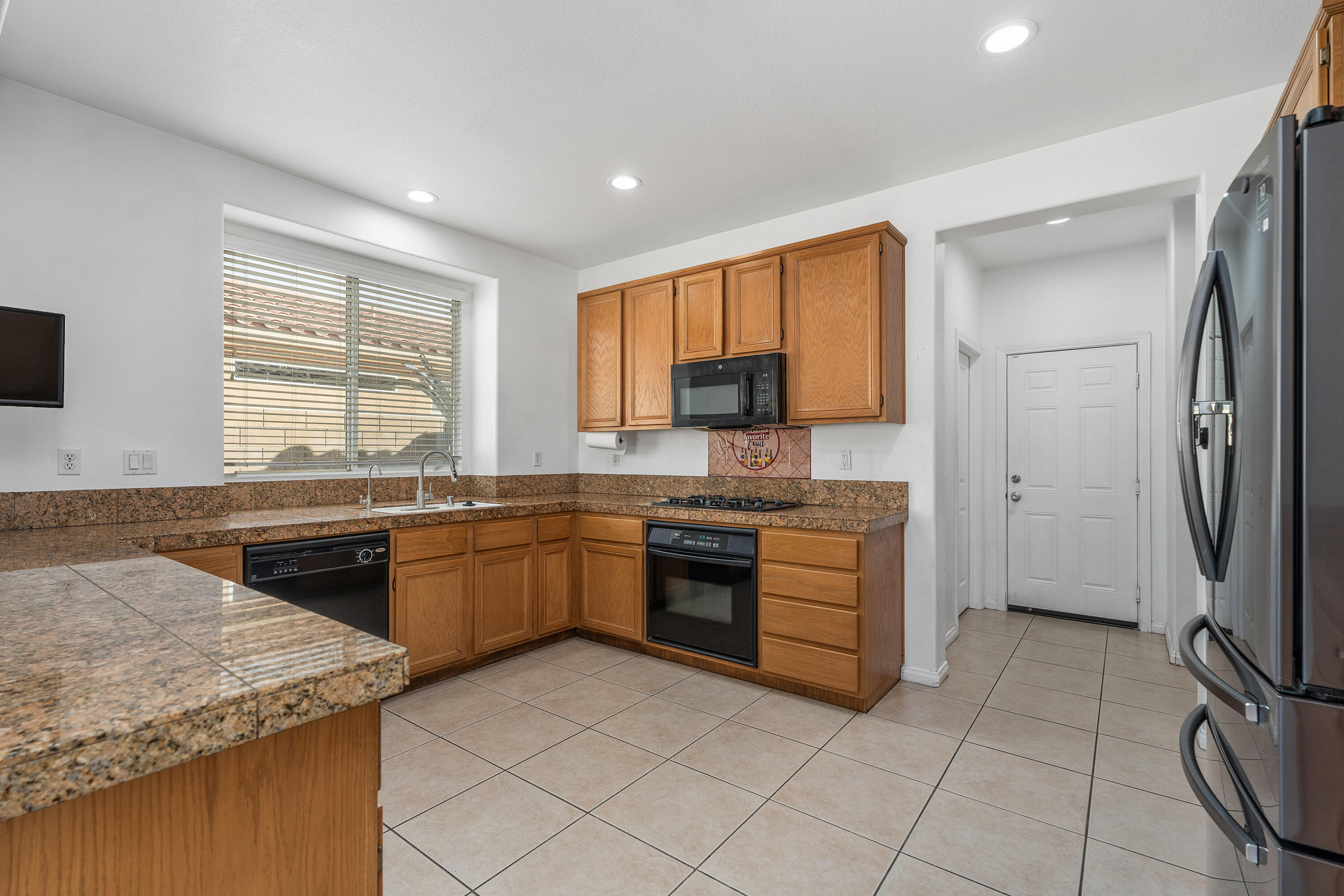 83814 Wolf Creek Road Indio, CA 92203 - Photo 11 of 28 a kitchen with stainless steel appliances granite countertop a sink stove and refrigerator