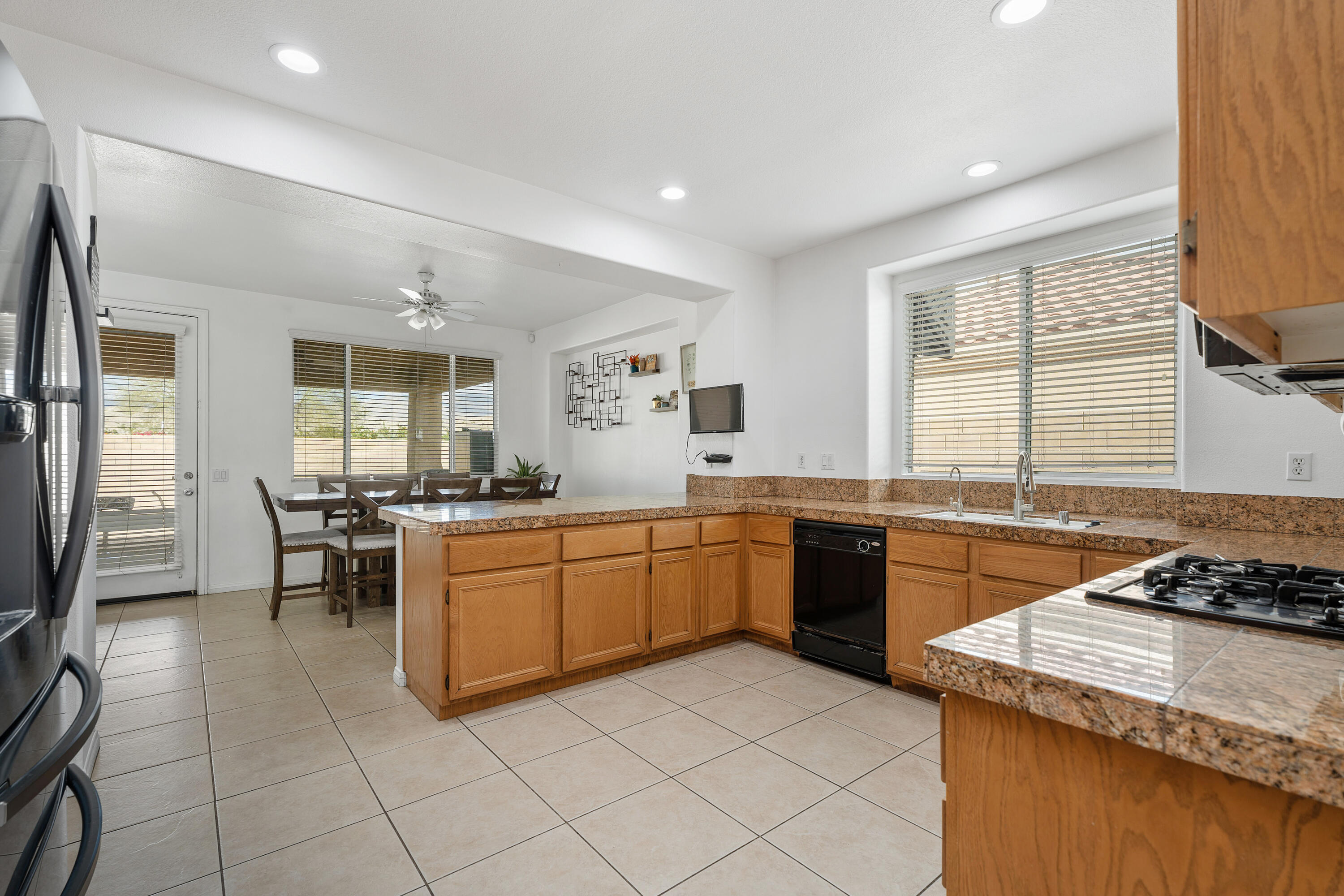 83814 Wolf Creek Road Indio, CA 92203 - Photo 12 of 28 a kitchen with stainless steel appliances granite countertop sink stove top oven and cabinets