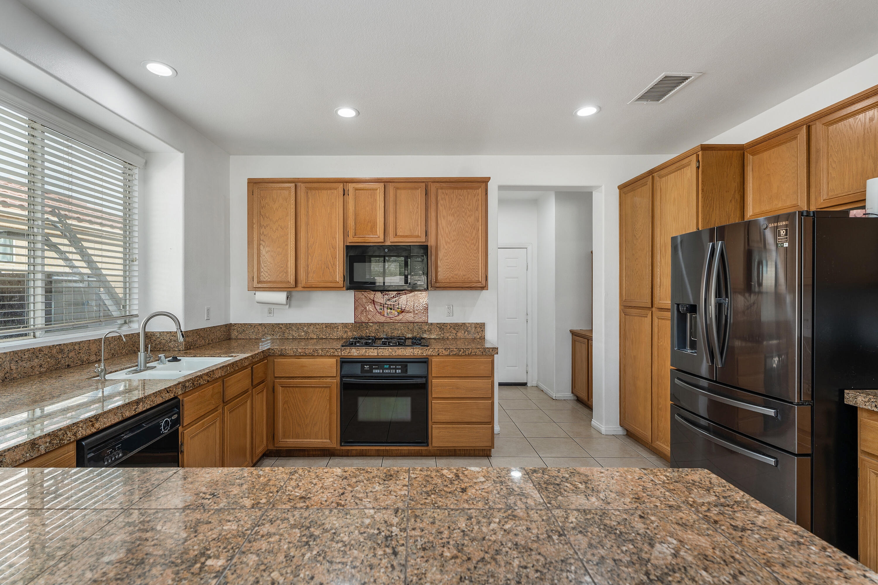 83814 Wolf Creek Road Indio, CA 92203 - Photo 14 of 28 a kitchen with stainless steel appliances granite countertop a refrigerator a sink a stove a washer dryer and a refrigerator
