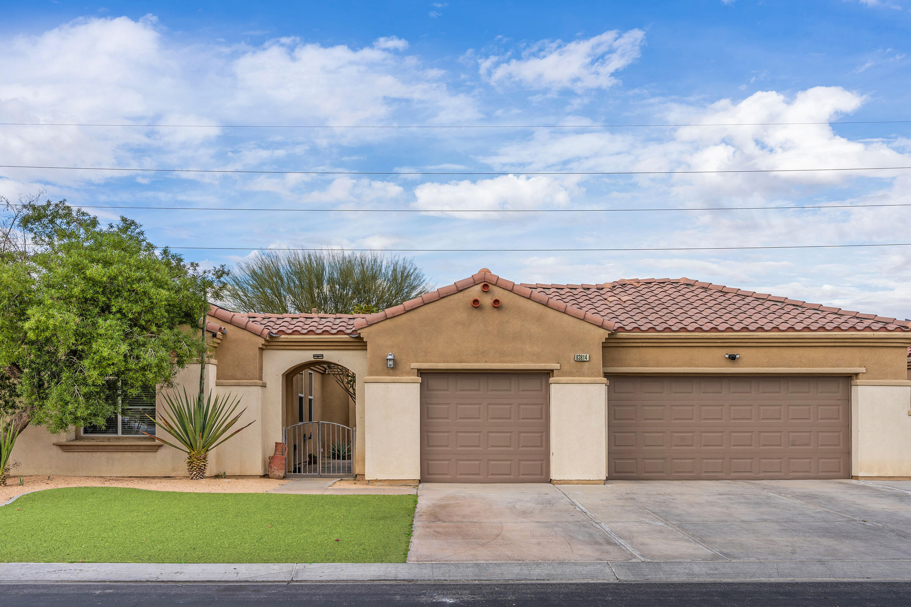 83814 Wolf Creek Road Indio, CA 92203 - Photo 2 of 28 a front view of a house with a yard and garage