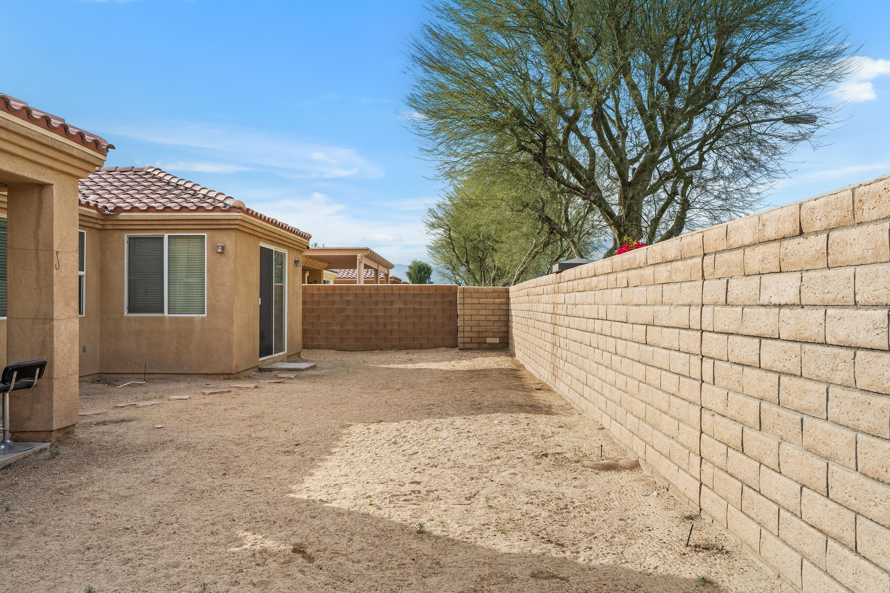 83814 Wolf Creek Road Indio, CA 92203 - Photo 26 of 28 a view of a white house with a large tree and wooden fence