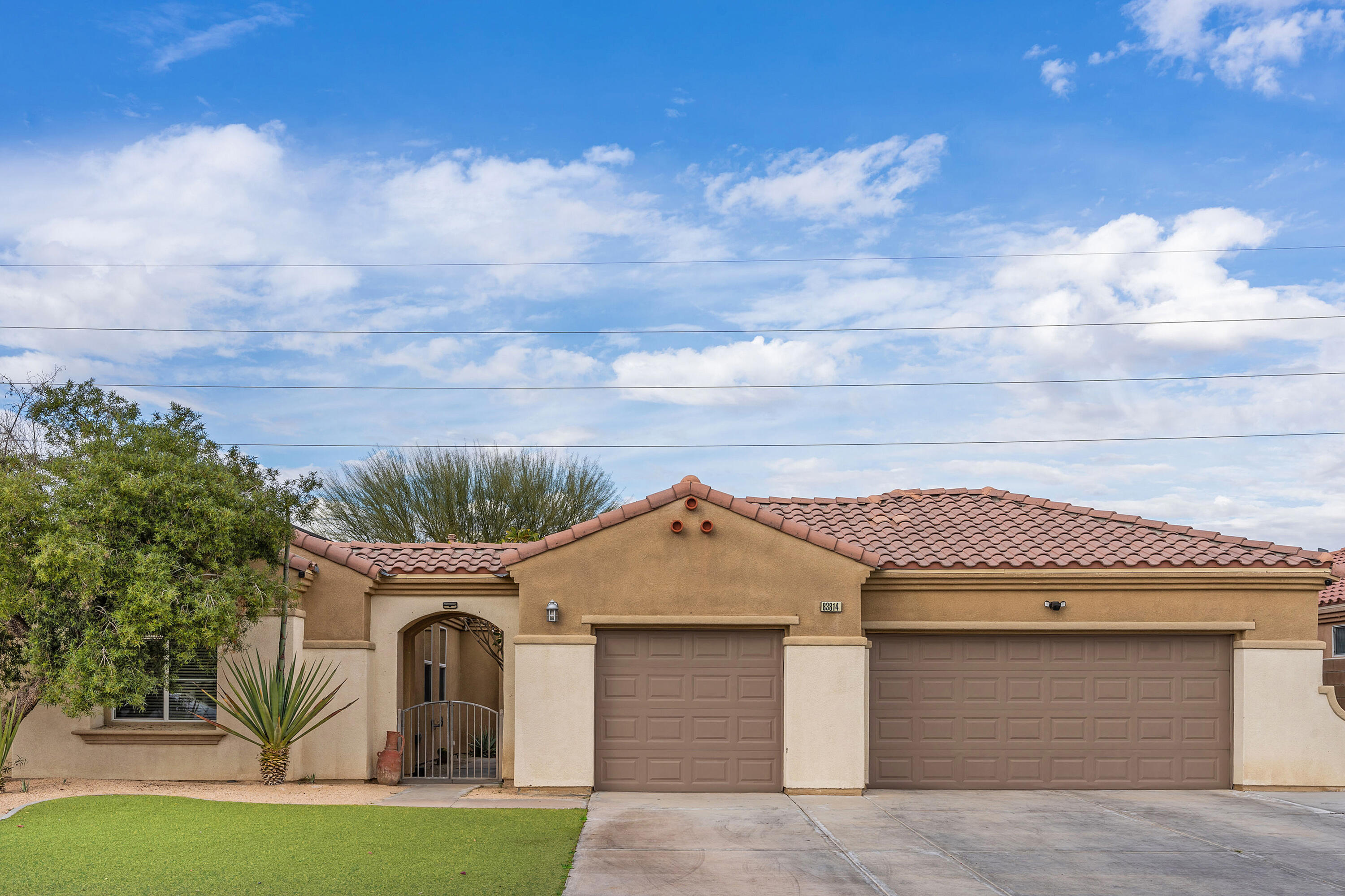 83814 Wolf Creek Road Indio, CA 92203 - Photo 3 of 28 a front view of a house with a garden and yard
