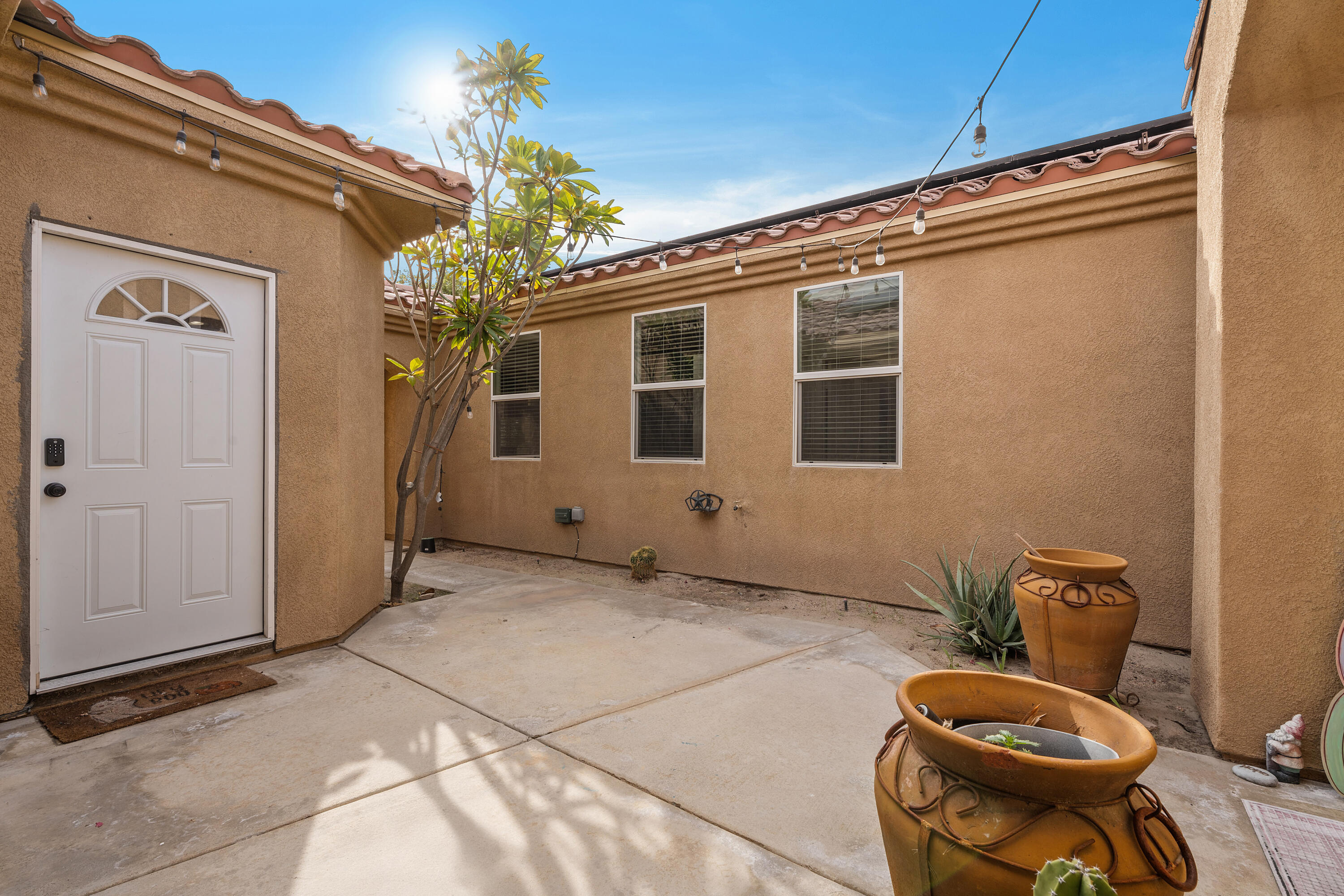 83814 Wolf Creek Road Indio, CA 92203 - Photo 6 of 28 a backyard of a house with table and chairs