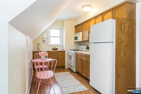 a kitchen with a refrigerator a stove a sink and white cabinets
