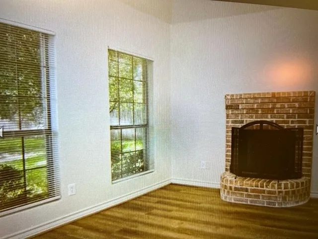 a view of fireplace with wooden floor and a window