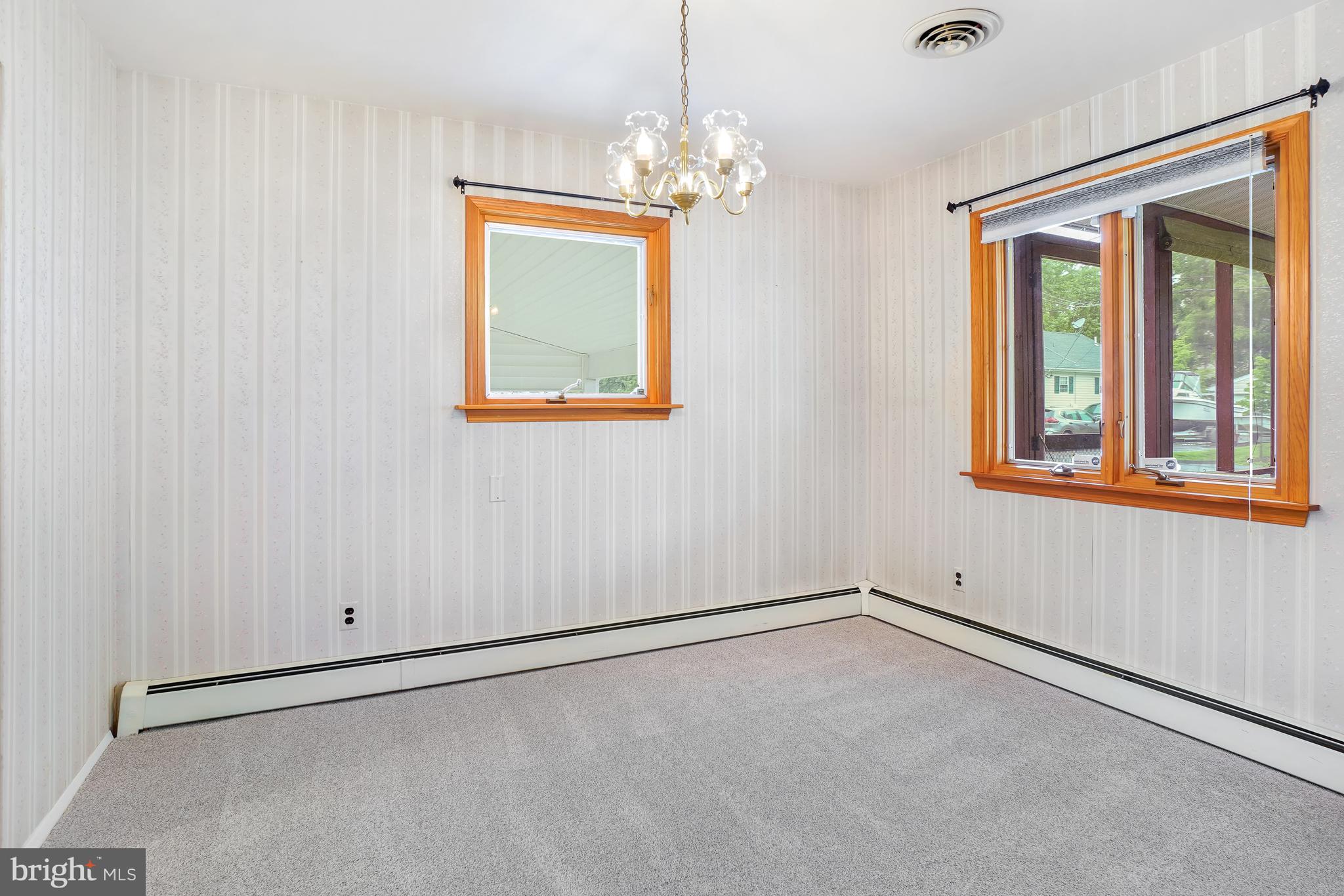 1403 Disney Road Severn, MD 21144 - Photo 11 of 39 an empty room with windows and chandelier