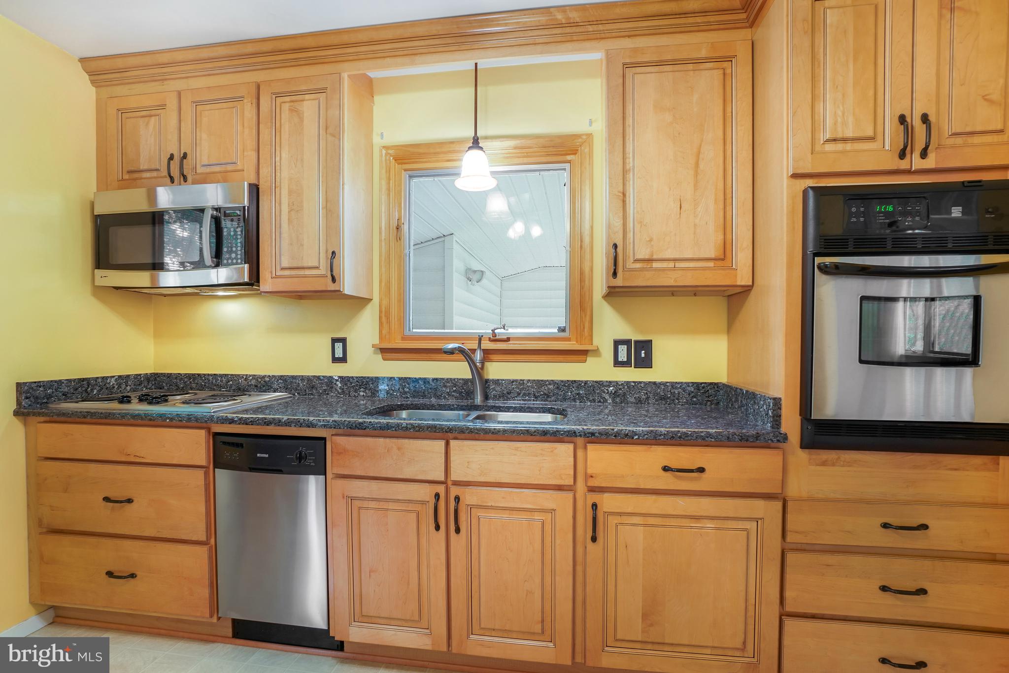 1403 Disney Road Severn, MD 21144 - Photo 13 of 39 a kitchen with granite countertop a sink and a stove