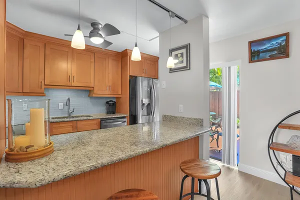 a kitchen with stainless steel appliances granite countertop a sink a refrigerator and a granite counter tops