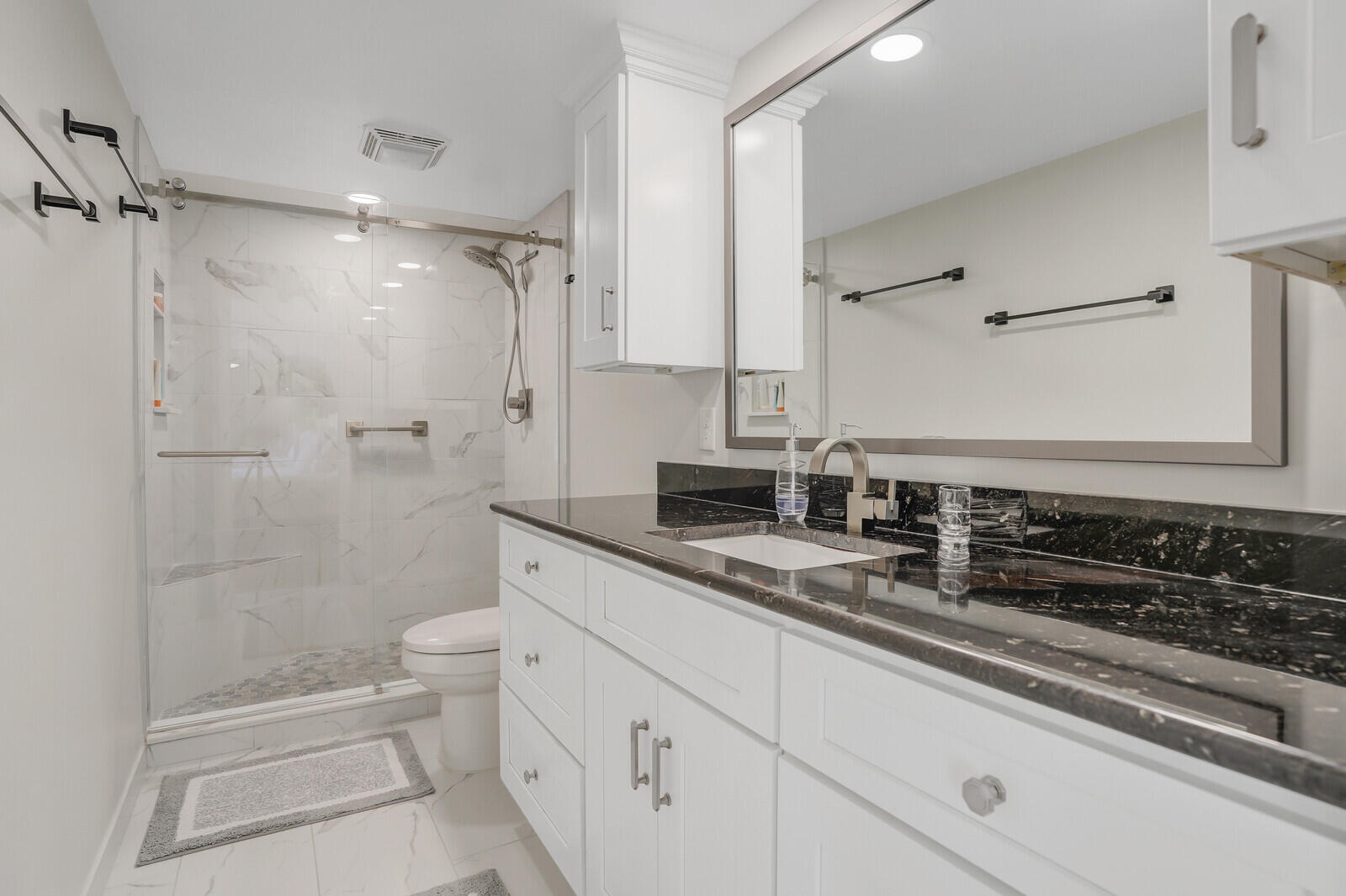 825 Center Street, Unit 14A Jupiter, FL 33458 - Photo 23 of 57 a bath room with a toilet a sink and a shower