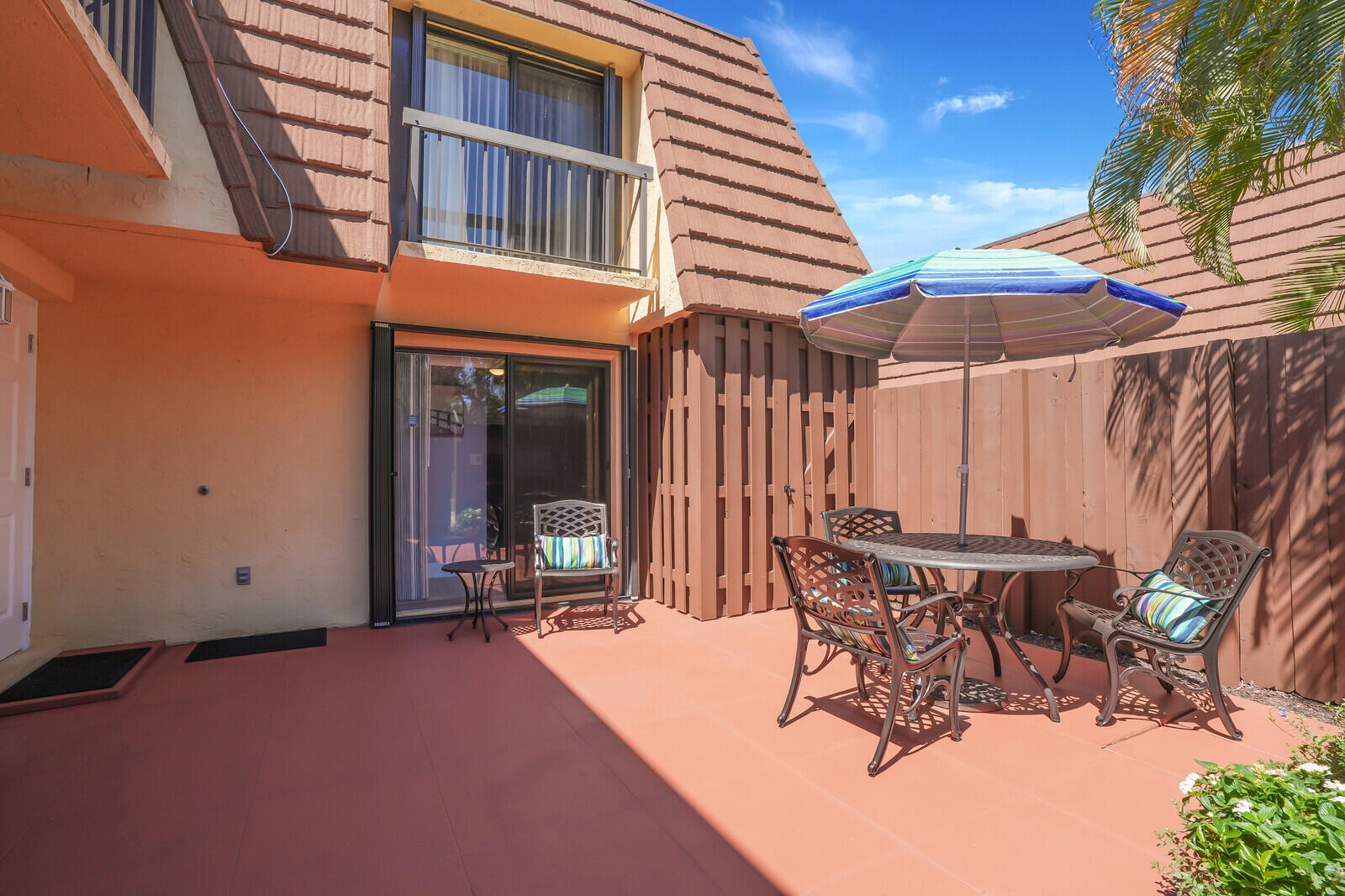 825 Center Street, Unit 14A Jupiter, FL 33458 - Photo 30 of 57 a patio with a table and chairs under an umbrella