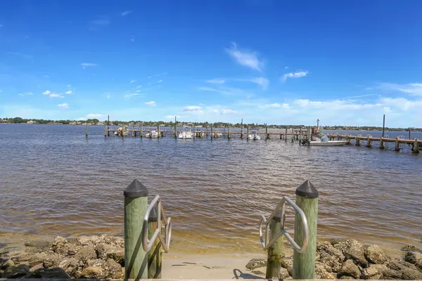a view of a pathway both side of grassy field with building in background