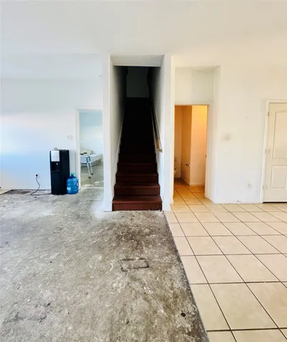 a view of a livingroom with wooden floor and stairs