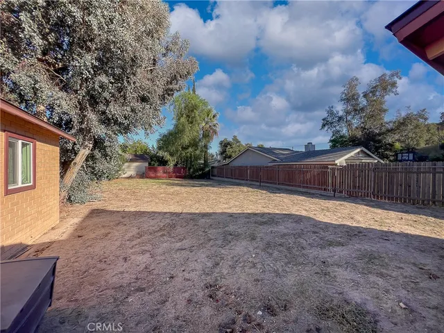 a view of a backyard with wooden fence
