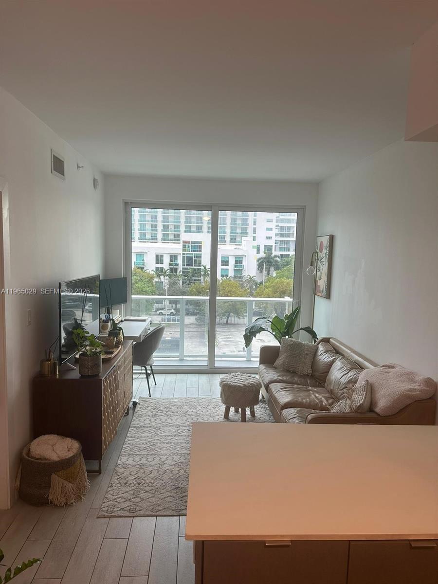 321 Northeast 26th Street, Unit 511 Miami, FL 33137 - Photo 5 of 13 a living room with furniture and a floor to ceiling window