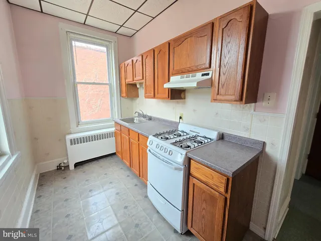 a kitchen with a stove a sink and a refrigerator