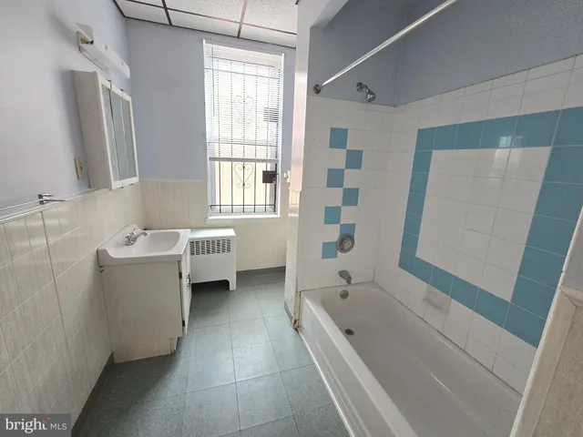 a bathroom with a tub a sink and a mirror