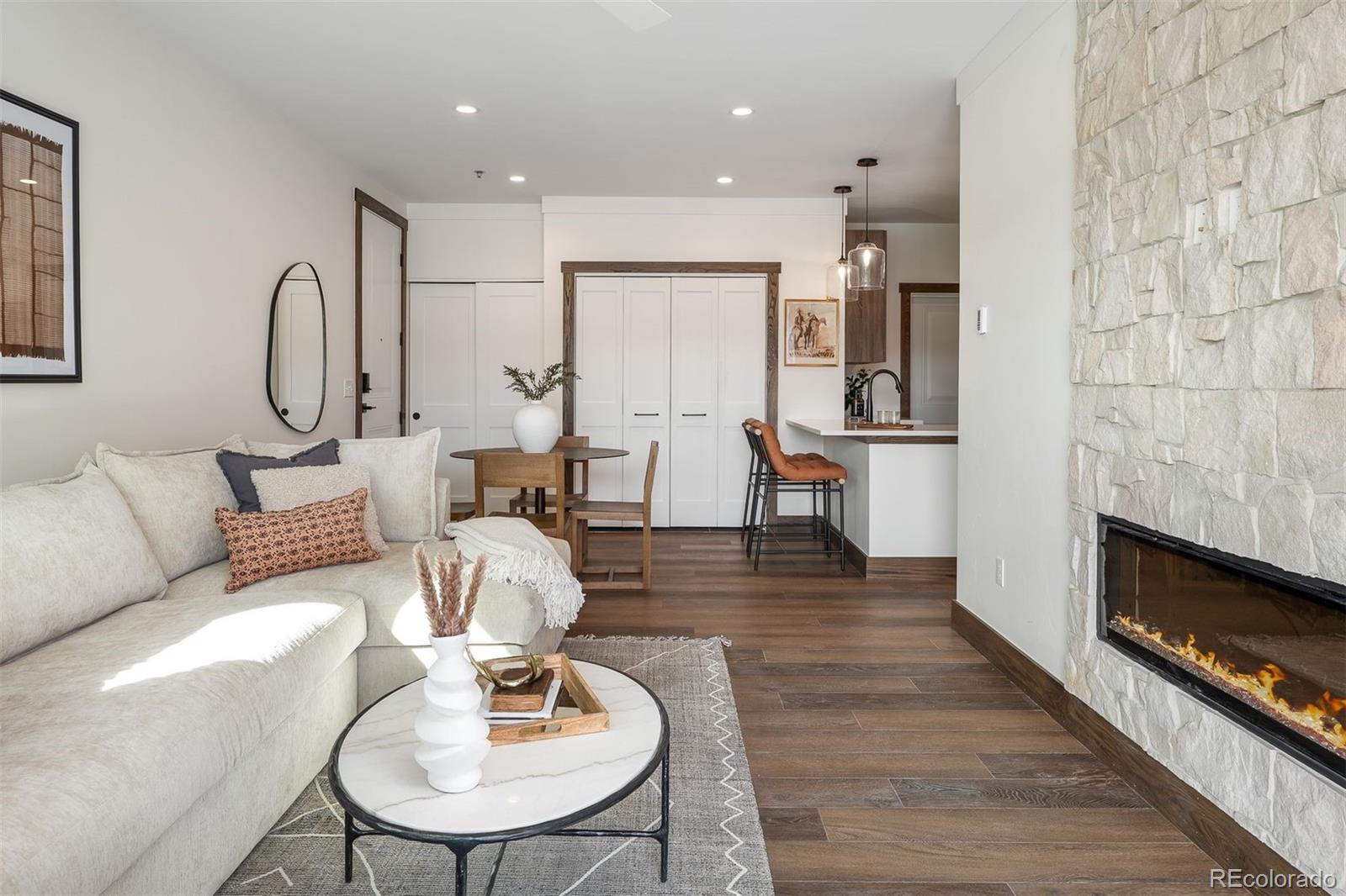 340 Sterling Loop, Unit 1 Fraser, CO 80442 - Photo 11 of 28 a living room with couches chairs and kitchen view with wooden floor