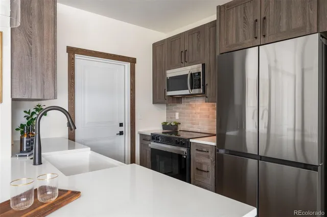 a kitchen with stainless steel appliances a refrigerator sink and cabinets