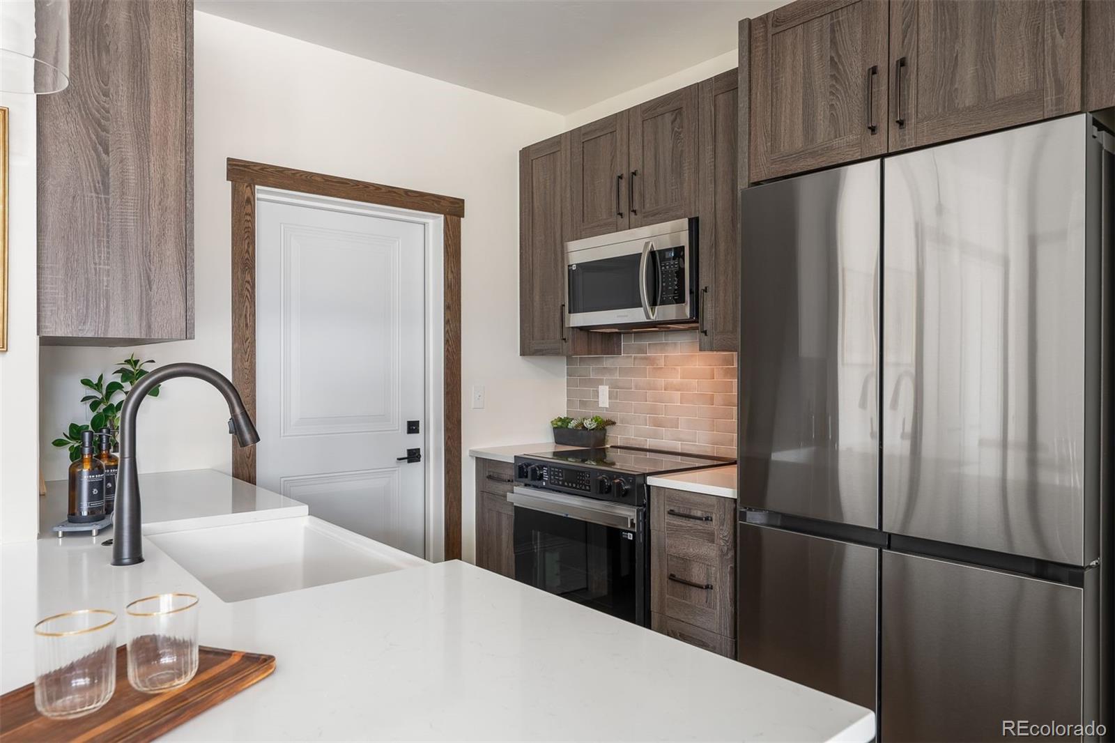 340 Sterling Loop, Unit 1 Fraser, CO 80442 - Photo 12 of 28 a kitchen with stainless steel appliances a refrigerator sink and cabinets