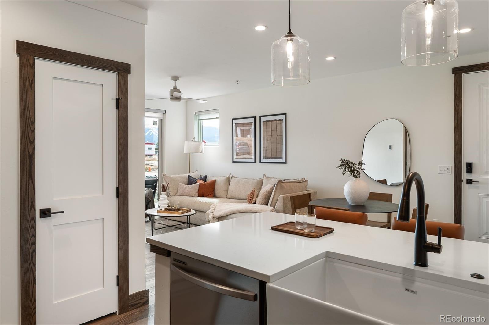 340 Sterling Loop, Unit 1 Fraser, CO 80442 - Photo 3 of 28 a kitchen with a sink dishwasher a dining table and chairs with wooden floor