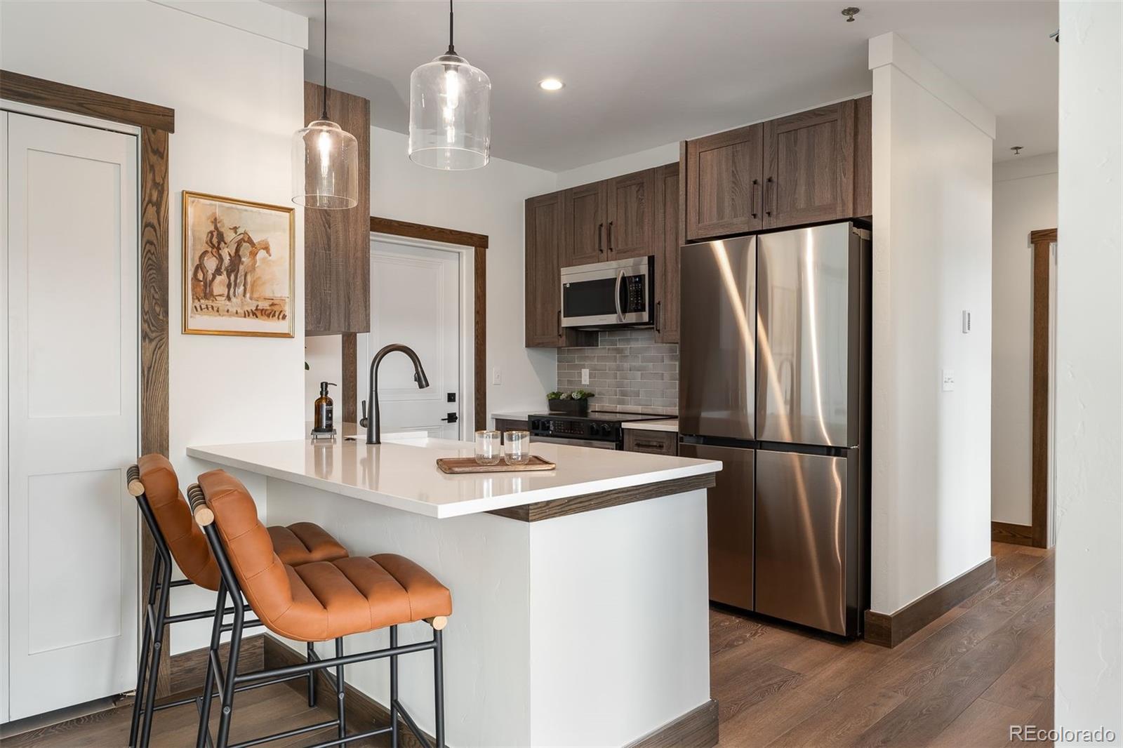 340 Sterling Loop, Unit 1 Fraser, CO 80442 - Photo 8 of 28 a kitchen with stainless steel appliances granite countertop a refrigerator a stove a sink cabinets a dining table and chairs