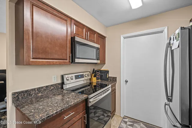 a kitchen with stainless steel appliances granite countertop a refrigerator and a microwave