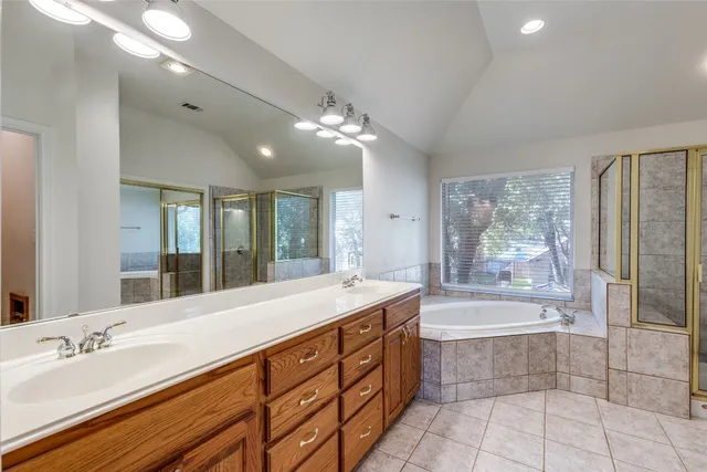 a spacious bathroom with a tub sink and mirror