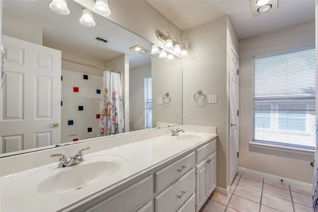 a bathroom with a double vanity sink mirror double and shower