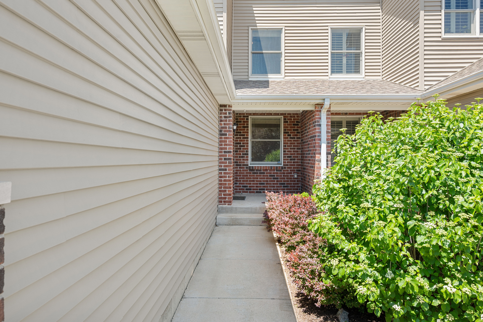 3705 Green Tree Lane DeKalb, IL 60115 - Photo 2 of 31 a pathway of a house with potted plants